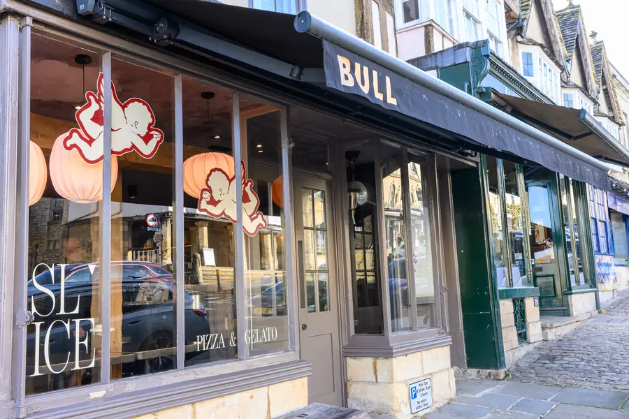 A High Street shopfront in Burford with a Bull sign and large display windows